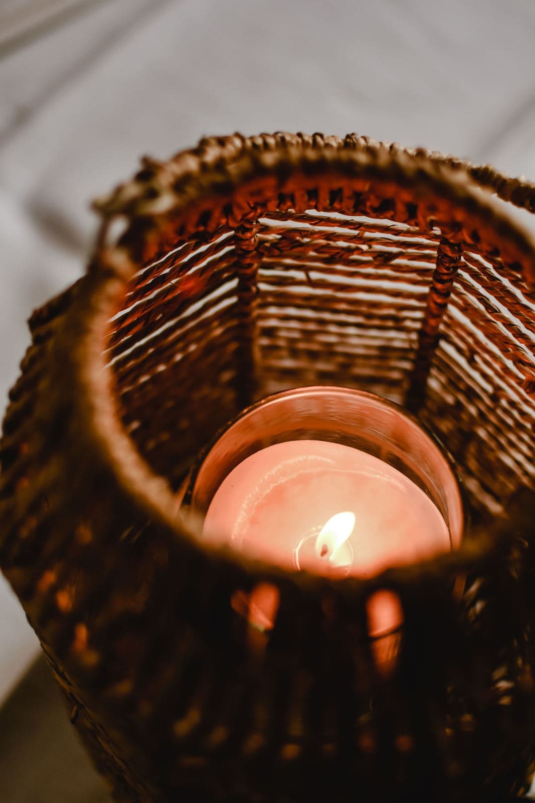 Lit candle in a woven basket